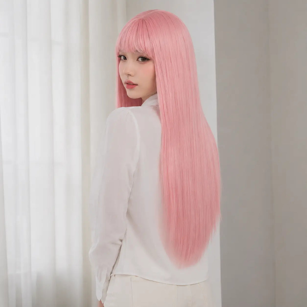 Back view of pastel pink 26 inch straight wig with bangs