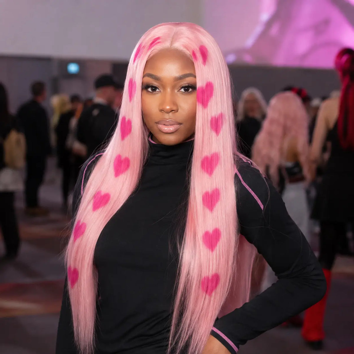 Model wearing pink heart print straight wig at cosplay event