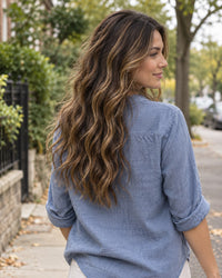 Illustrative highlighted natural-wave hairstyle outdoors, viewed from behind.